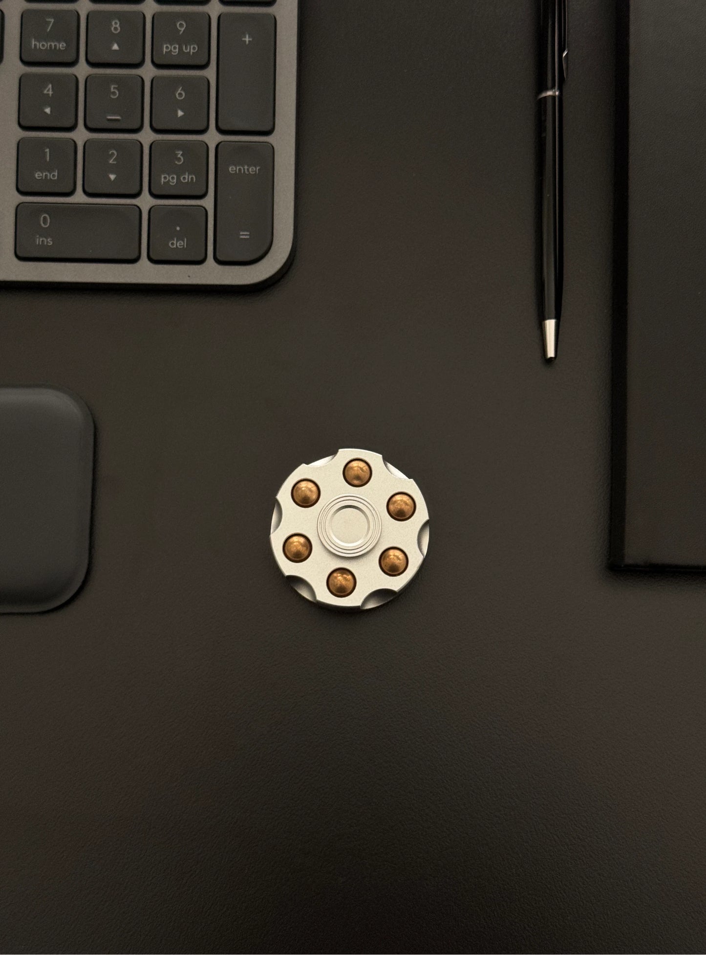 Spinner placed on a work desk beside a keyboard, illustrating everyday use.
