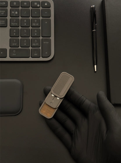 Magnetic 3-Layer Fidget Slider held in hand on a desk alongside a keyboard and notebook, illustrating its compact size and suitability for workspace use.​
