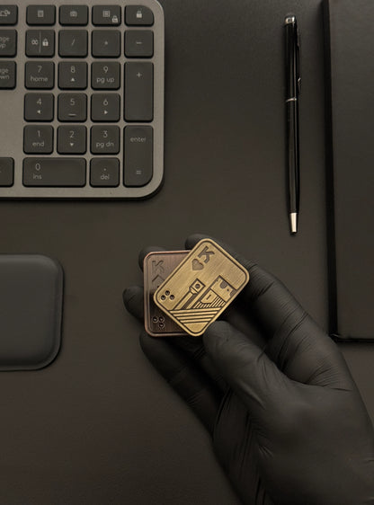 Metal Poker Card Fidget Toy held in hand on a desk alongside a keyboard and notebook, illustrating its compact size and suitability for workspace use.​
