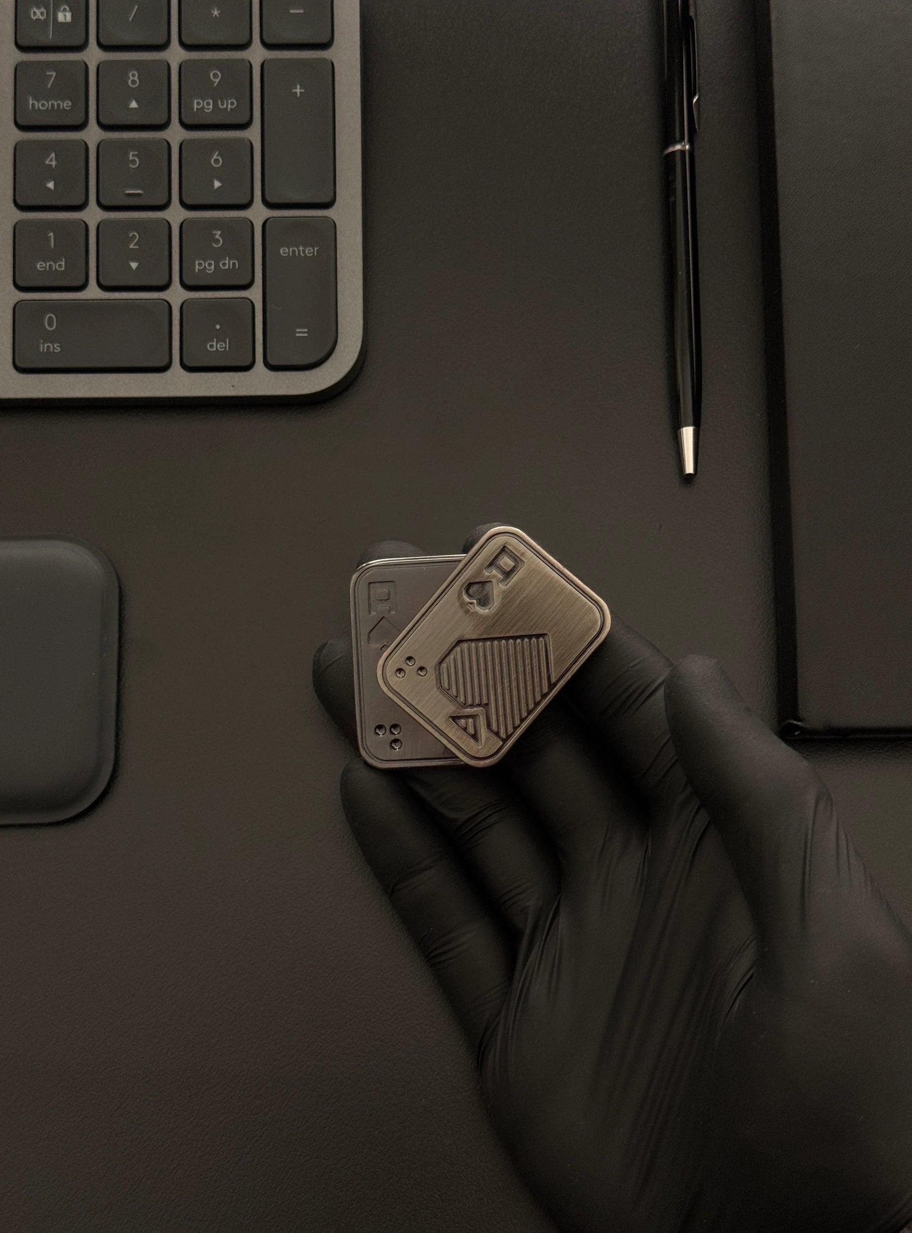 Toy held in hand on a desk with keyboard and notebook, demonstrating its size and workplace use.
