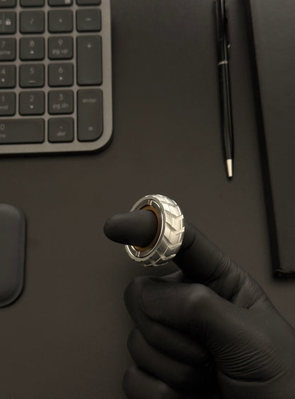 Spinner in hand on a desk beside a keyboard and notebook, illustrating portability.