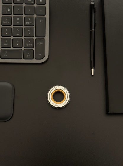 Spinner placed on a desk with a keyboard and notebook, demonstrating its compactness.