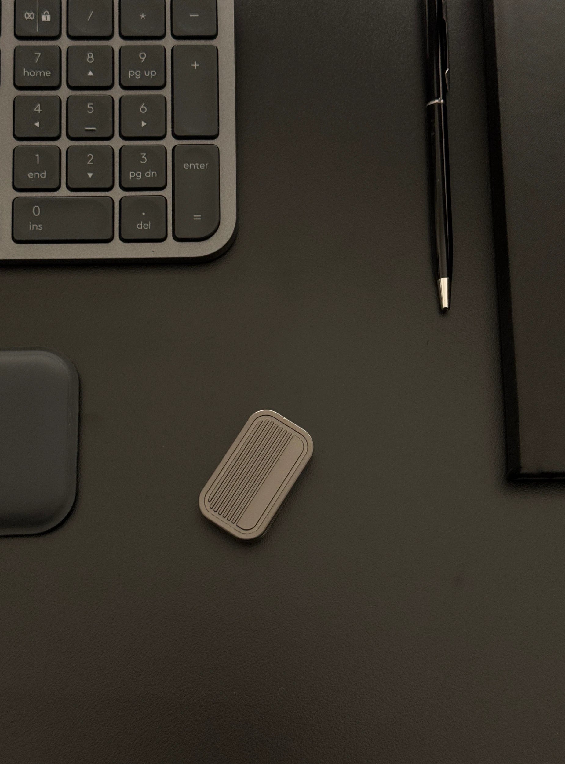 Magnetic 3-Layer Fidget Slider placed on a desk with a keyboard and notebook, depicting its discreet presence in a professional environment.​
