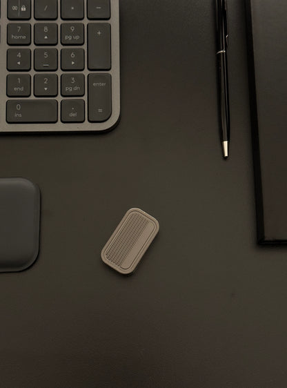 Magnetic 3-Layer Fidget Slider placed on a desk with a keyboard and notebook, depicting its discreet presence in a professional environment.​
