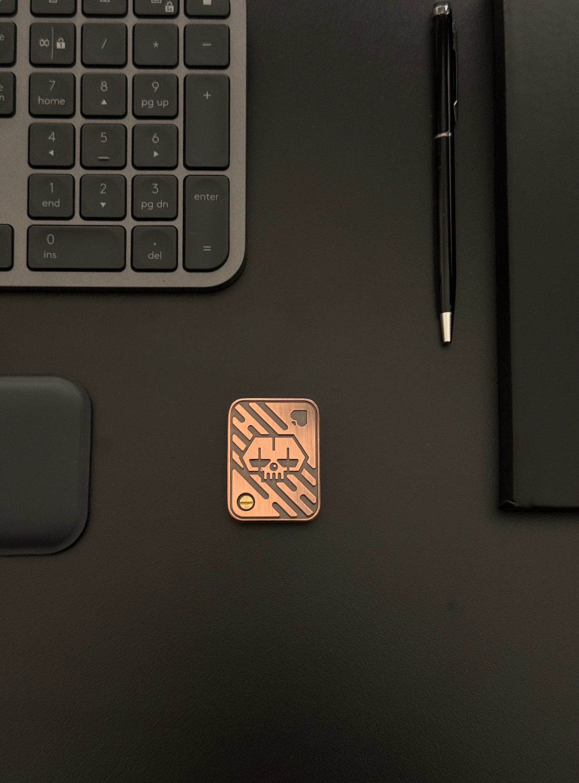 Metal Poker Card Fidget Toy placed on a desk with a keyboard and notebook, depicting its discreet presence in a professional environment.​

