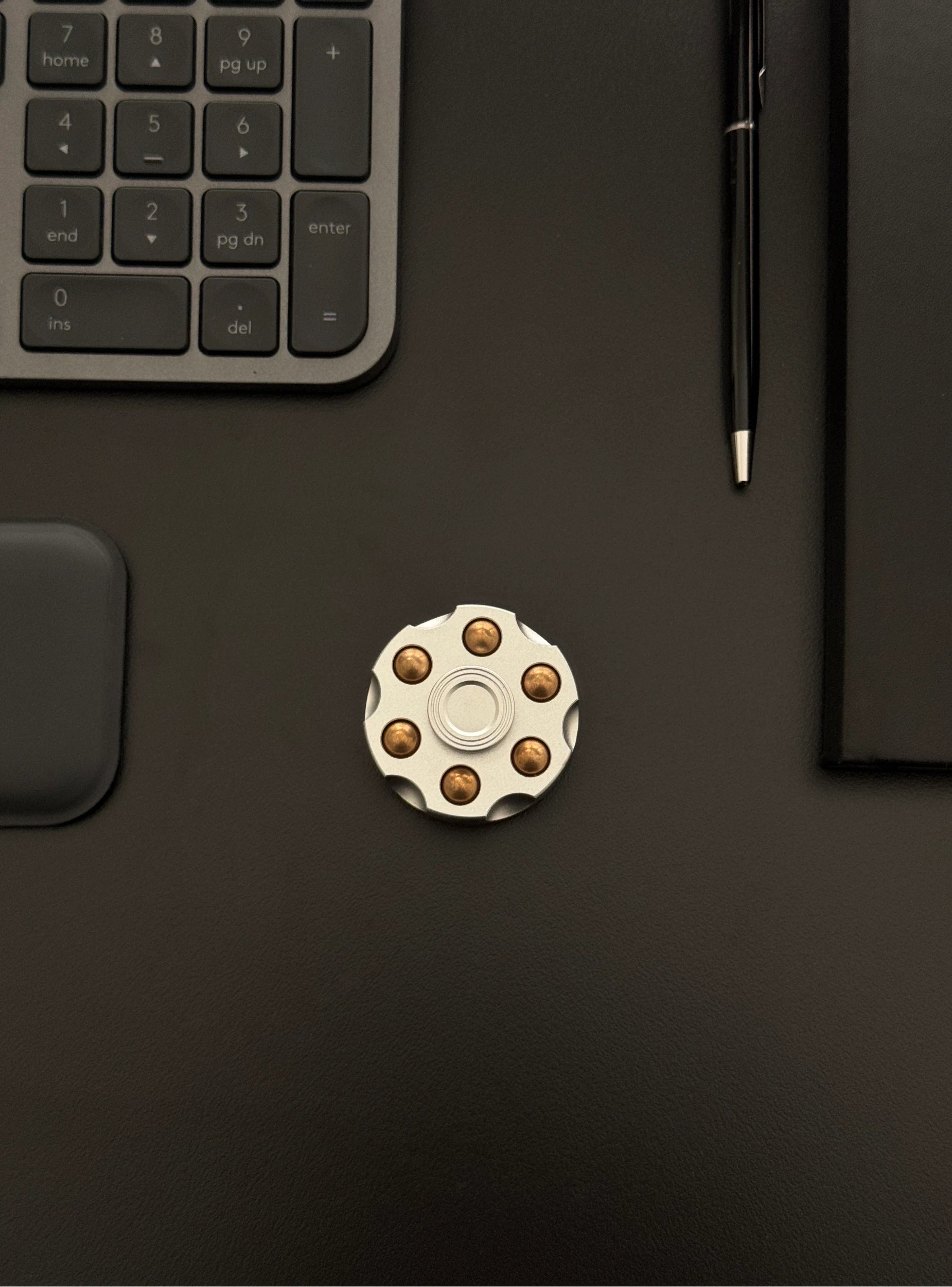 Spinner placed on a work desk beside a keyboard, illustrating everyday use.