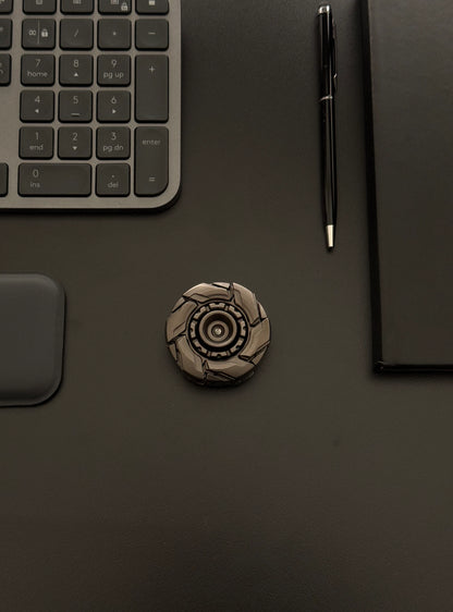Robust metal fidget toy placed next to work accessories, emphasizing its premium and adult-oriented build
