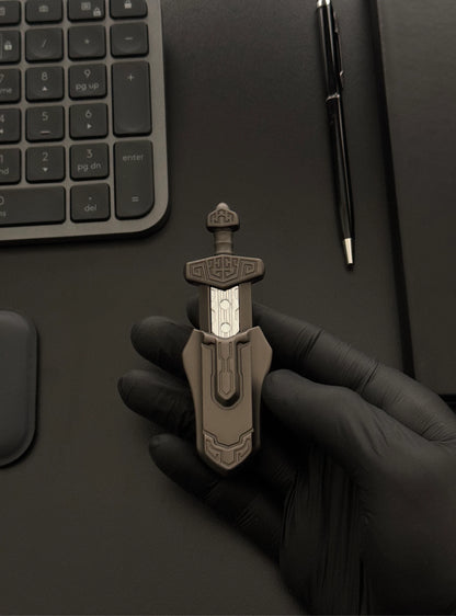 Magnetic Sword Slider placed on a desk with a keyboard and notebook in the background.
